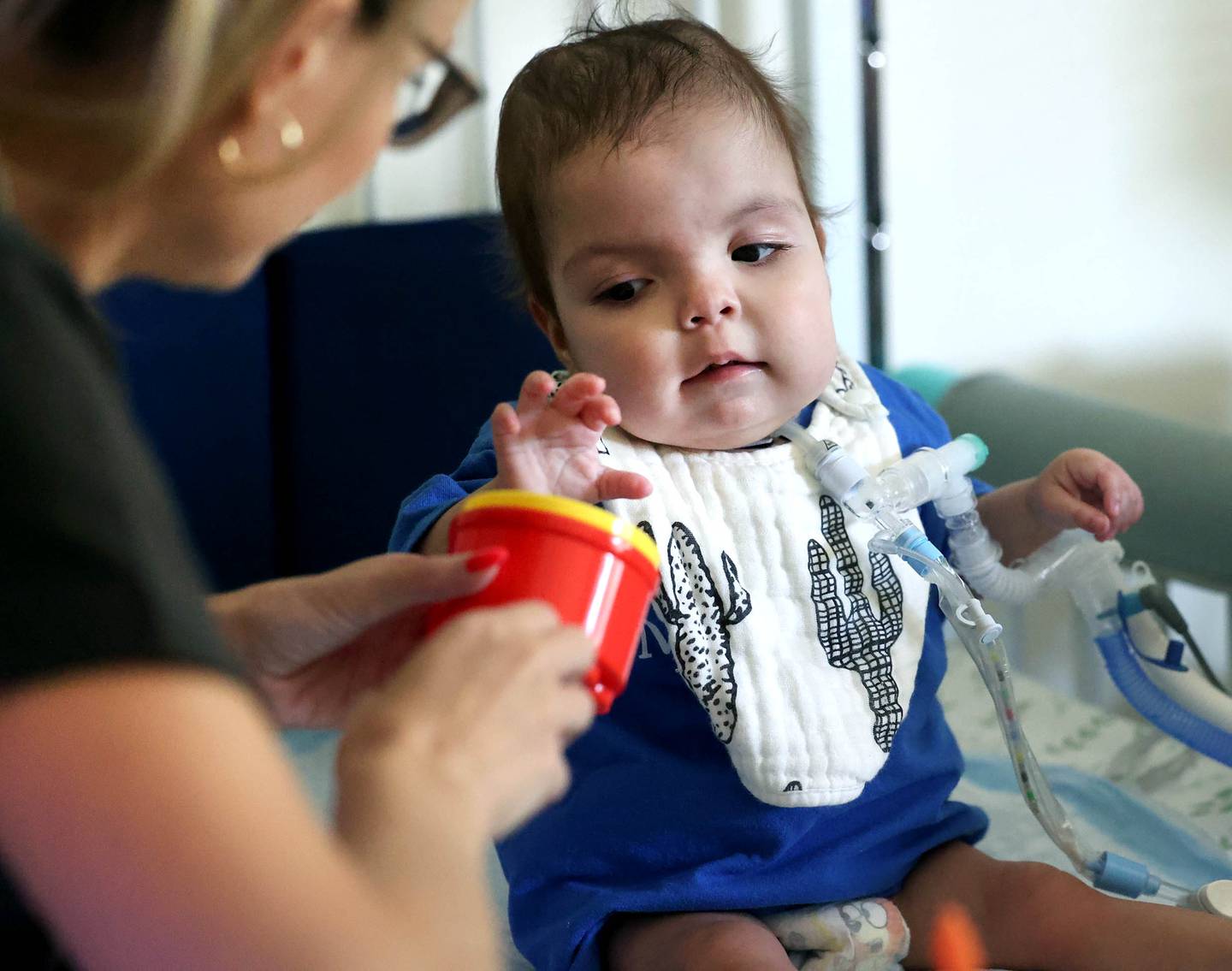 Marely Chavarria Santos, 1, works on her motor skills with home visitor Miranda Bates Monday, June 30, 2025, at Marely’s home in DeKalb. Marely was born with a myriad of health issues that require around-the-clock care and recently received a heart transplant.