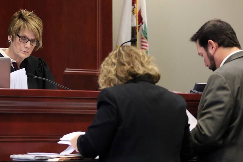 Judge Robbin Stuckert (left), along with Assistant State's attorney Alicia Caplan and defense attorney Bob Motta (right) review their schedules to pick a date to hear a motion to suppress evidence relating to the criminal felony charge involving the possession of and dissemination of child pornography for Motta's client Corey Butler, Pastor at Jesus Is The Way Christian Center in DeKalb, on Wednesday, Nov. 1, 2017 at the DeKalb County Courthouse Sycamore.  Butler had been offered a plea deal in the April 2015 charge but is choosing to fight the charges in court.  He is due in court again on Jan. 4; a trial date has not yet been set.