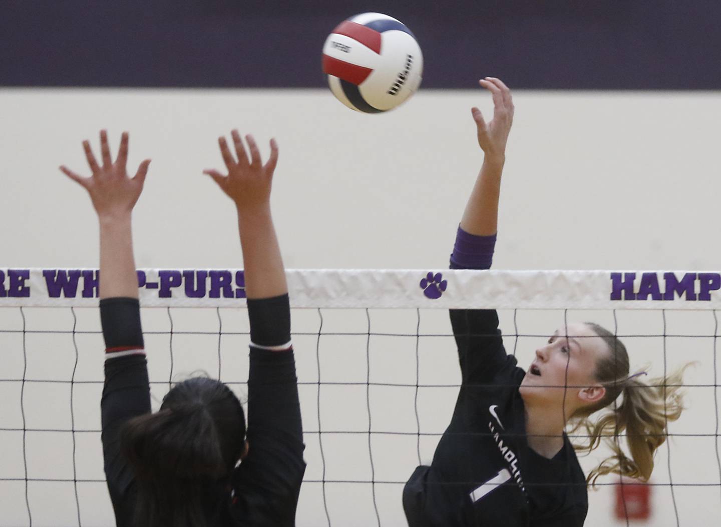Hampshire's Elizabeth King hits the ball over the block attempt of Mundelein's Donnelley Wyss during an IHSA Class 4A Hampshire Sectional semifinal volleyball match on Tuesday, Nov. 4, 2025, at Hampshire High School.