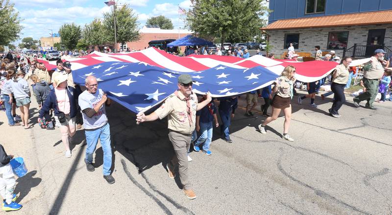 Boyscouts and Cubscouts carry a large American flag down South Main Street during the 54th annual Homestead Festival parade on Saturday, Sept. 6, 2025 in Princeton.