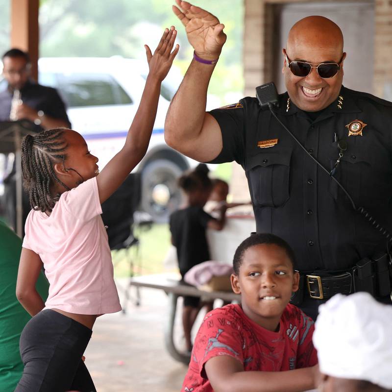 Mariah Cotton, 10, from DeKalb, gets a high five from DeKalb Police Chief David Byrd after she beat him in Uno during Fun Jam in the Park Tuesday, June 27, 2023, at Welsh Park in DeKalb. Fun Jam in the Park offers constructive activities for kids on Tuesday and Thursday through August 8th from 5-7 p.m. at various parks in DeKalb.