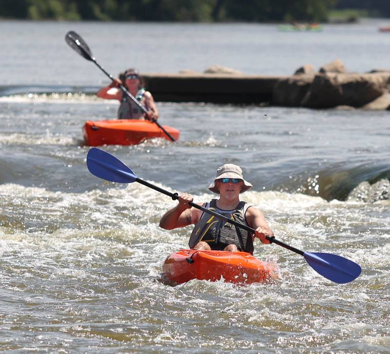 Kirk (front) and Buffie Lange, from Elwood, kayak through the Marge Cline Whitewater Course Monday, July 18, 2021, in the Fox River in Yorkville.