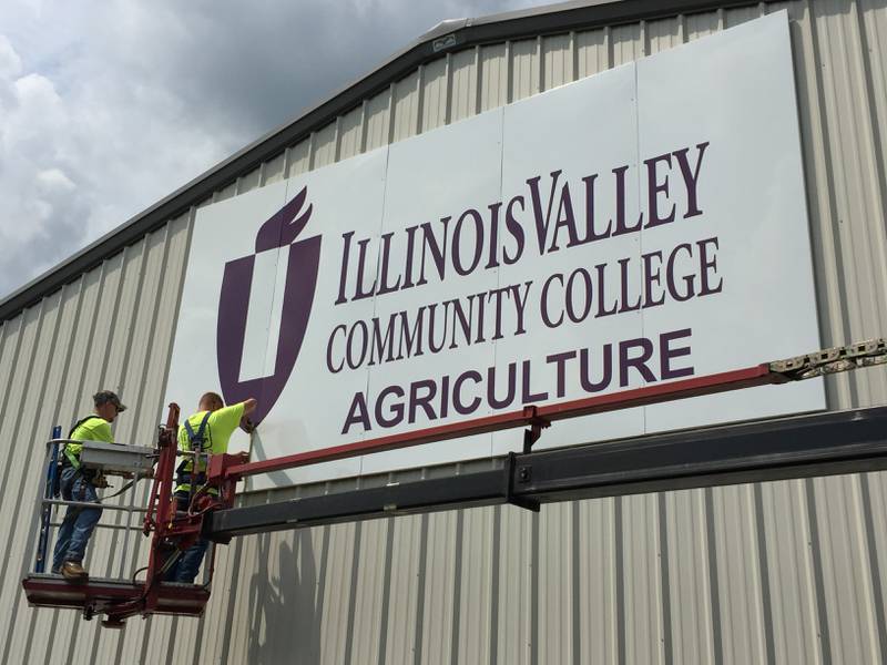 Field technicians from Designs & Signs by Anderson apply the final screws to a new 10-by-20-foot sign on the east side of Illinois Valley Community College’s new ag facility. As of Aug. 6, there were 52 students enrolled in fall ag classes with 12 days remaining before the Aug. 18 semester start.