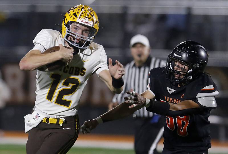 Jacobs' Connor Goehring runs away from McHenry's Elijah Guardyak during a Fox Valley Conference football game on Friday, Oct. 18, 2024, at McCracken Field in McHenry.