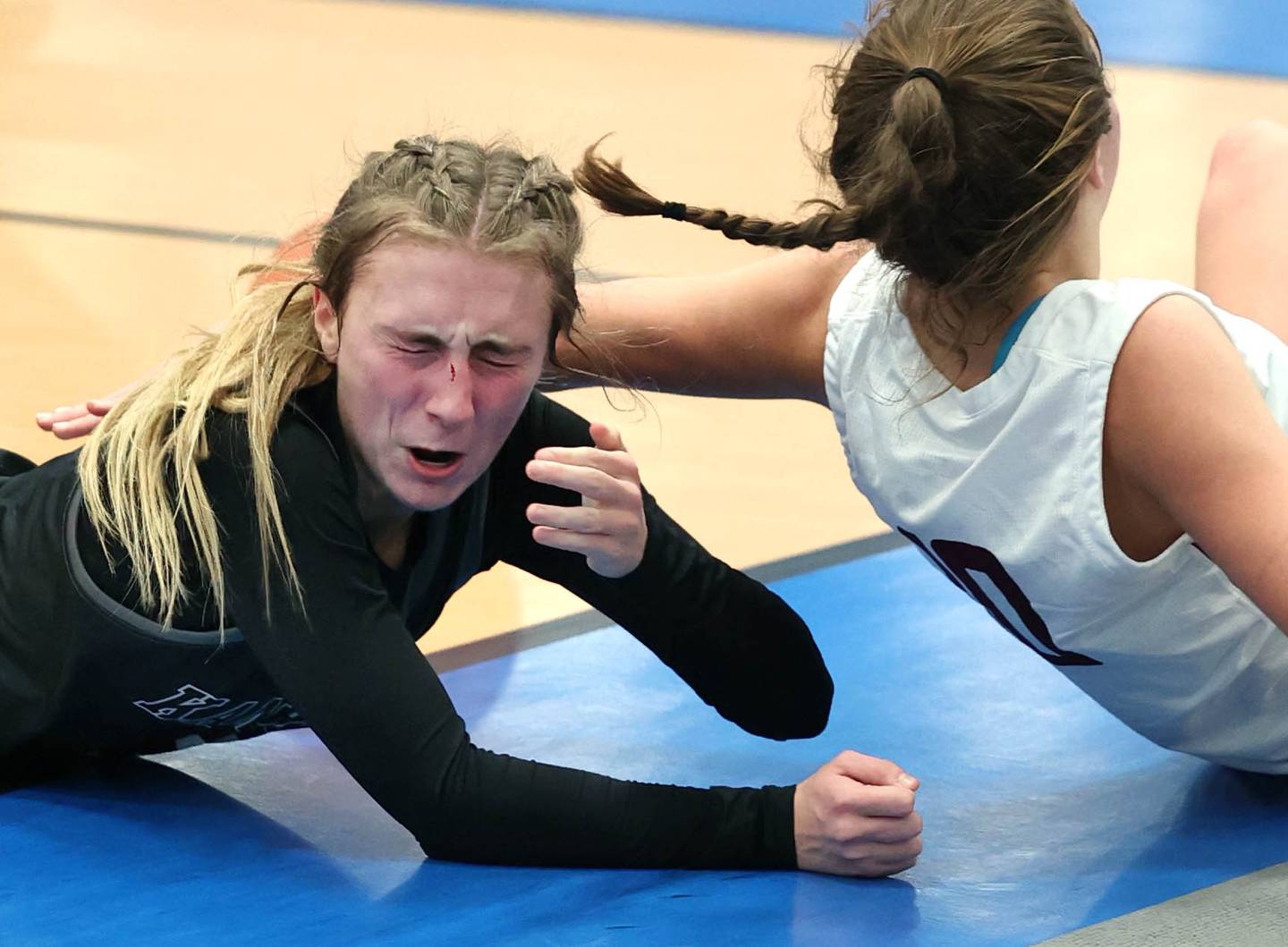 Kaneland's Alexis Schueler comes up with a cut nose after Prairie Ridge's Ali Storz falls on her going after a loose ball during their game Friday, Nov. 17, 2023, in the Mark Einwich Varsity Girls Basketball Rockets Kickoff Tournament at Burlington Central High School.