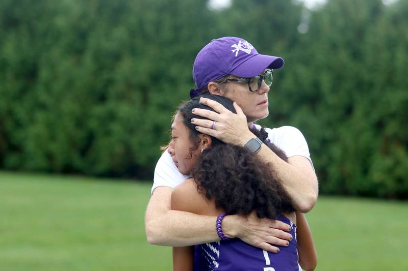 Hampshire’s Assistant Coach Cindy Wagner comforts varsity runner Miya Morgana after the Fox Valley Conference Cross Country Meet at McHenry County College in Crystal Lake on Saturday, October. 18, 2025.
