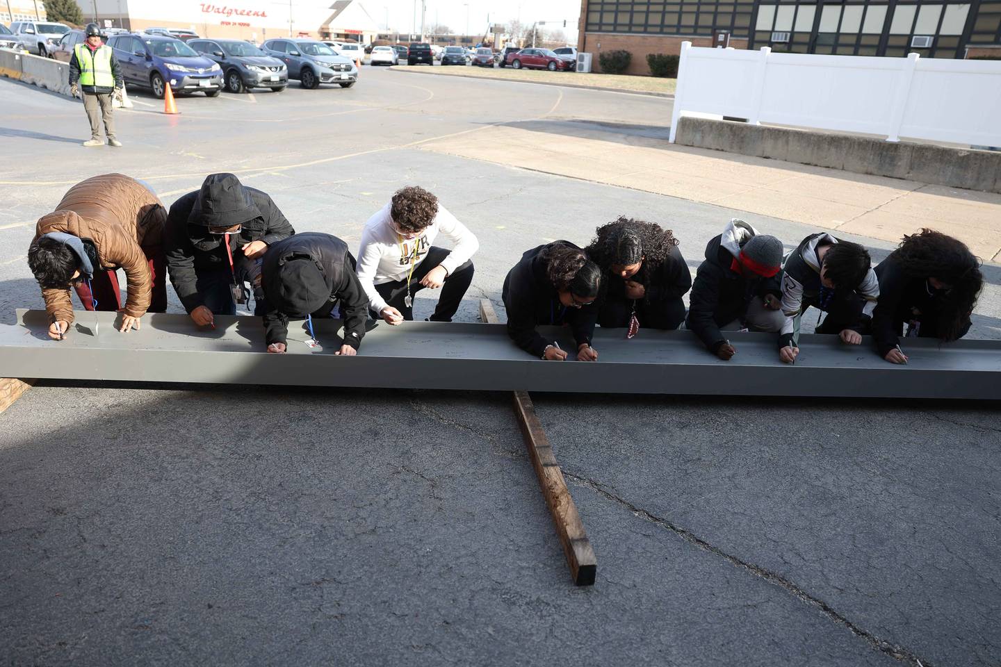 Hufford Junior High School students sign a beam that will be used to build the new school on Friday, Dec. 13, 2024 in Joliet.