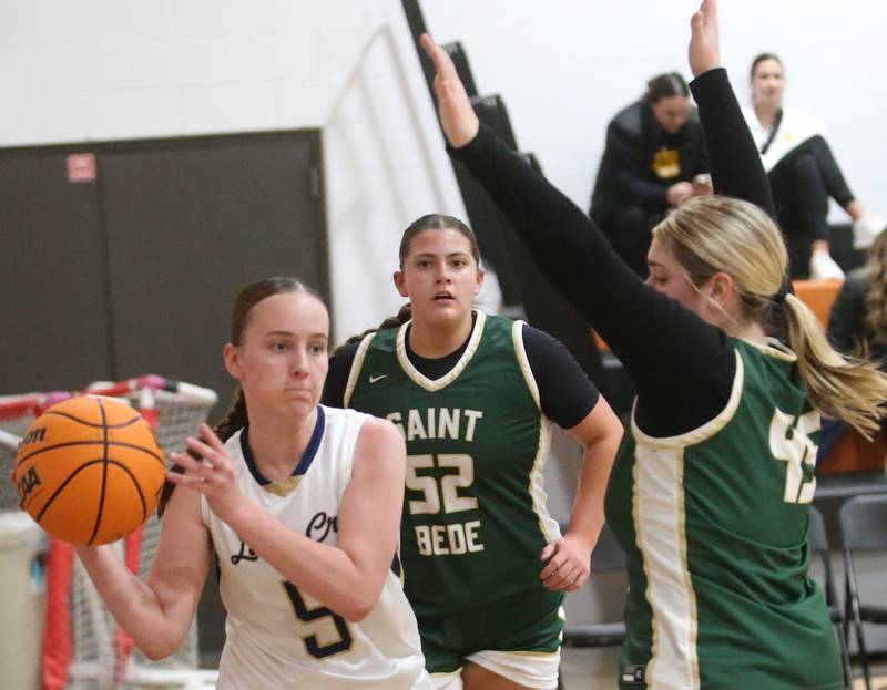 Marquette's Chloe Larson dribbles around St. Bede's Savannah Bray during the Tri-County Conference championship game on Thursday, Jan. 23, 2025 at Roanoke-Benson High School.