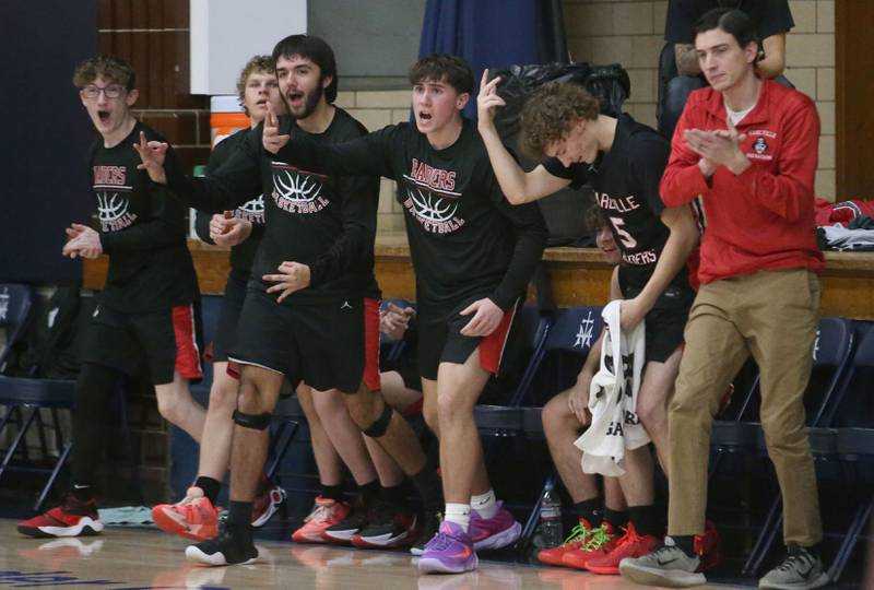 Earlville players react after teammate Easton Fruit sinks a jump shot against Marquette on Friday, Jan. 3, 2025 in Bader Gym at Marquette High School.