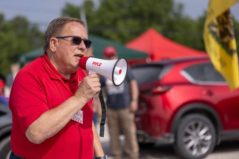 Larry Smith speaks to the rally participants prior to the start of the caravan outside of Jamie's Outpost during the caravan staging for the Trump Birthday and Flag Day Caravan and Rally on June 14, 2025 in Utica.
