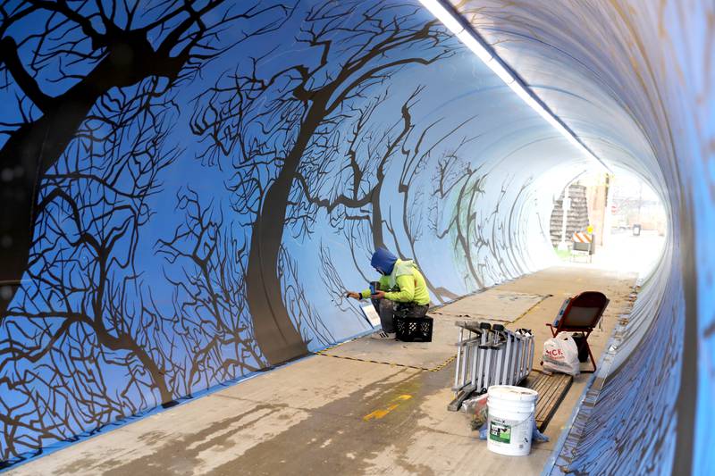 Artist Juan De La Mora works on his mural in the Taylor Avenue pedestrian underpass in Glen Ellyn on Wednesday, Nov. 16, 2022. De La Mora’s piece will feature the four seasons as you progress through the tunnel.
