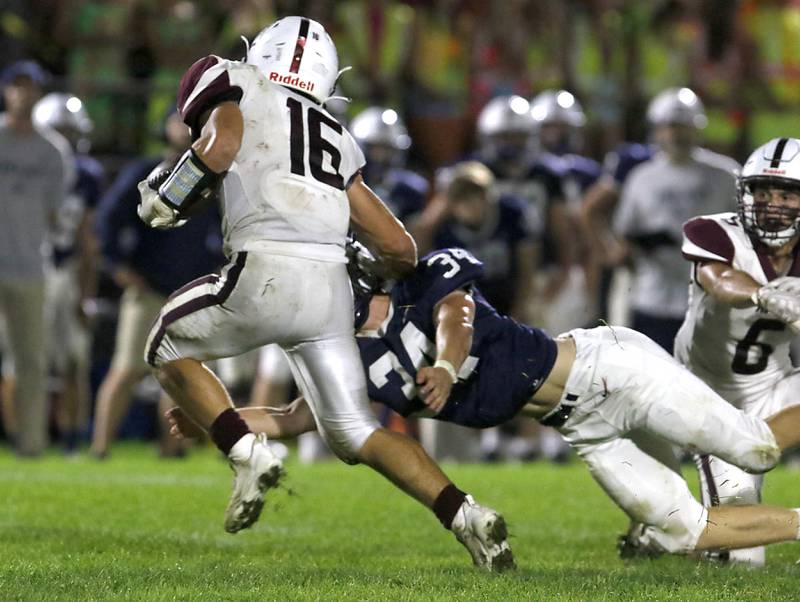 Prairie Ridge's Dominic Creatore runs through the tackle attempt Cary-Grove's Jack Rocenduring a Fox Valley Conference football game on Friday, Sept. 22, 2023, at Cary-Grove High School in Cary.