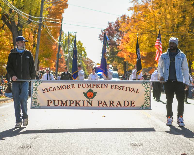 A Sycamore Pumpkin Festival Pumpkin Parade sign helps kick off the start of the parade on Sunday,  Oct. 27, 2024, in downtown Sycamore.