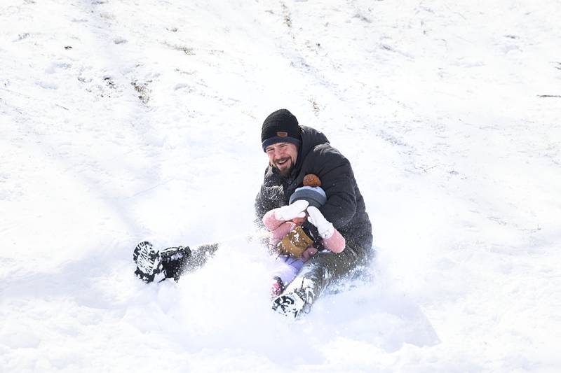 Cecily, 3, covers her eyes as dad Nick DeLancey takes her sledding Monday, March 16, 2026, at EC Smith Park in Dixon.