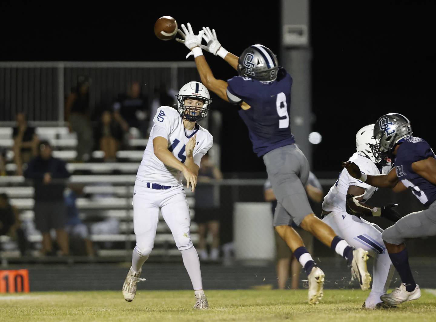 Plainfield South's Cody Hogan (15) tries to get the ball past Oswego East's Jake Boissiere (9) during the varsity football game between Plainfield South and Oswego East on Friday, Sep. 20, 2024, in Oswego.