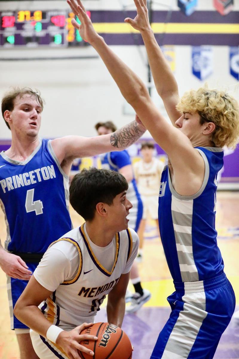 Mendota's Izaiah Nanez works between Princeton's Korte Lawson (4) and Landon Roarke Friday night. The Tigers won 60-47.