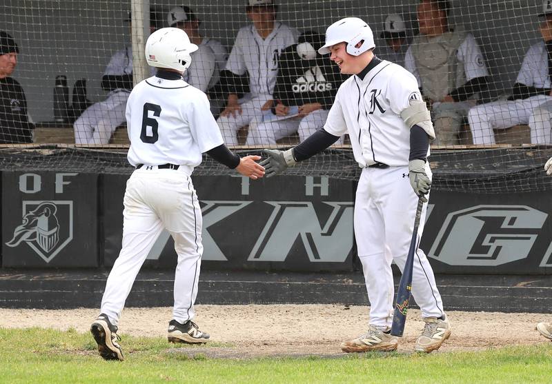 Kaneland's Caleb Cornell (left) is congratulated by teammates after scoring a run Tuesday, May 12, 2026, during their game against La Salle-Peru at Kaneland High School in Maple Park.