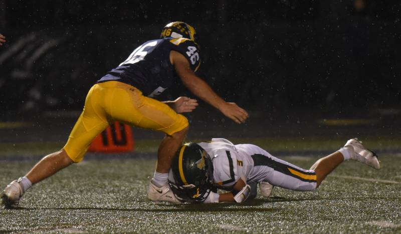 Glenbrook North's Reese Marquez dives on a dropped punt just before the arrival of Glenbrook South’s Hank Leahy during Friday’s game in Glenview.