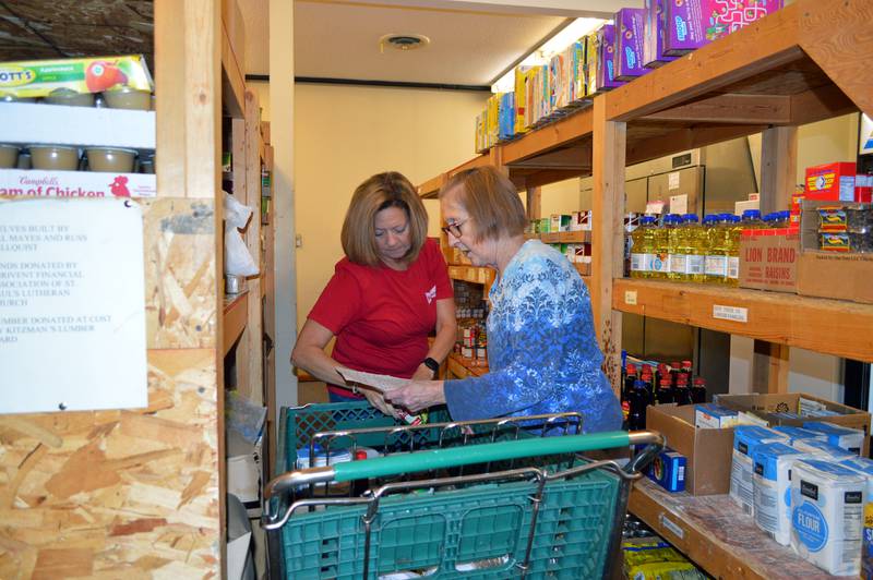 Dixon Community Food Pantry distribution team volunteers Jackey Phillips, right, and Laura Dunphy prepare a shopping cart full of items to go to a family in need on Friday, Nov. 10, 2023.