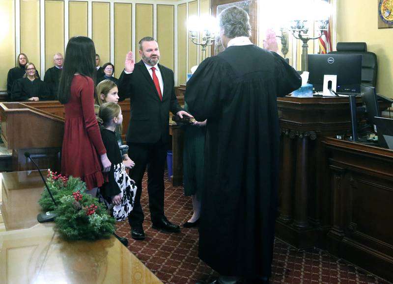 New DeKalb County State’s Attorney Riley Oncken, accompanied by his family, is sworn in by Chief Judge Bradley Waller Monday, Dec. 2, 2024, at the DeKalb County Courthouse in Sycamore.