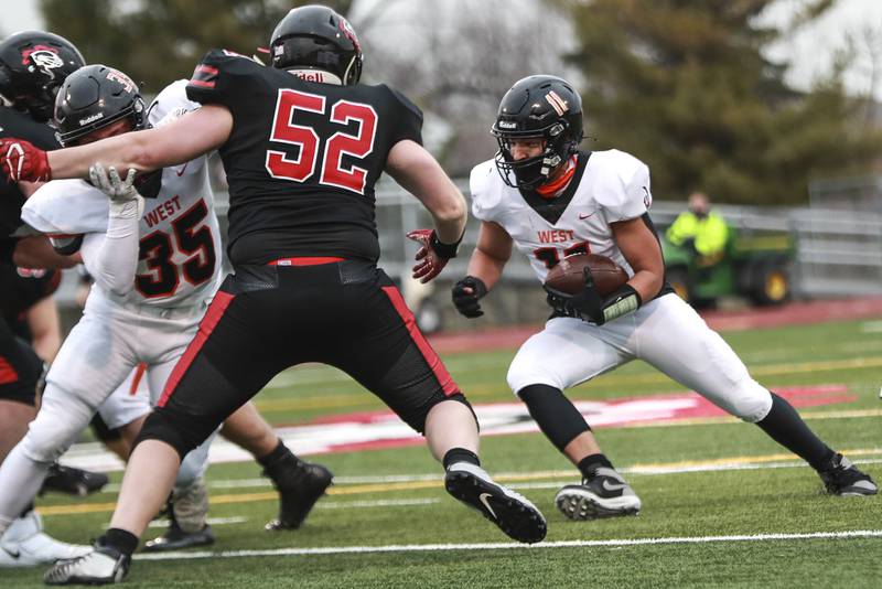 Lincoln-Way West's Justin Harris carries out of the backfield on Friday, March 26, 2021, at Lincoln-Way Central High School in New Lenox, Ill.