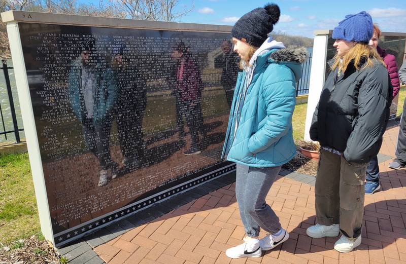 Members of the RiverGlen Christian Church reflect as they view the Middle East Conflicts Memorial Wall on Wednesday in Marseilles.