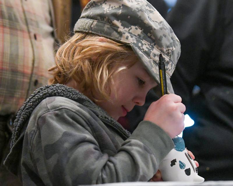 Holden McKeown, 6, Downers Grove paints a puppy bank during the craft portion of the Easter Egg Hunt event held at Cantigny Park on Sunday March 24, 2024.