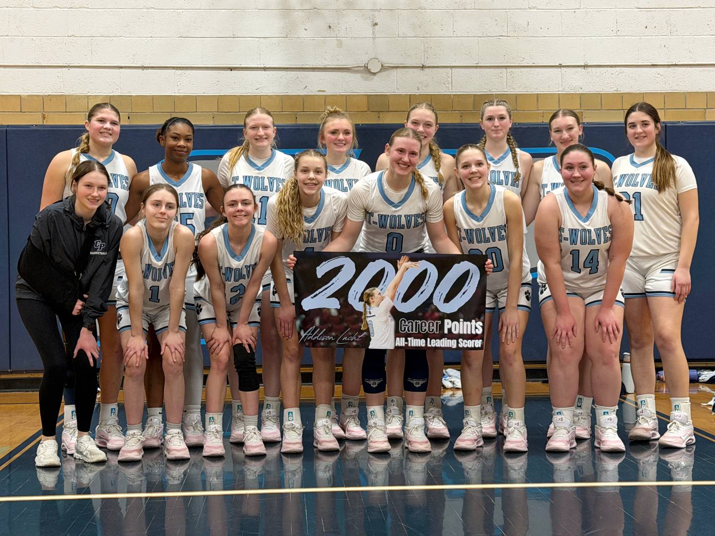 Cissna Park's Addison Lucht (0) poses with her teammates and her 2,000 career point banner after reaching the milestone during a home game against Clifton Central Wednesday, Feb. 4, 2026.