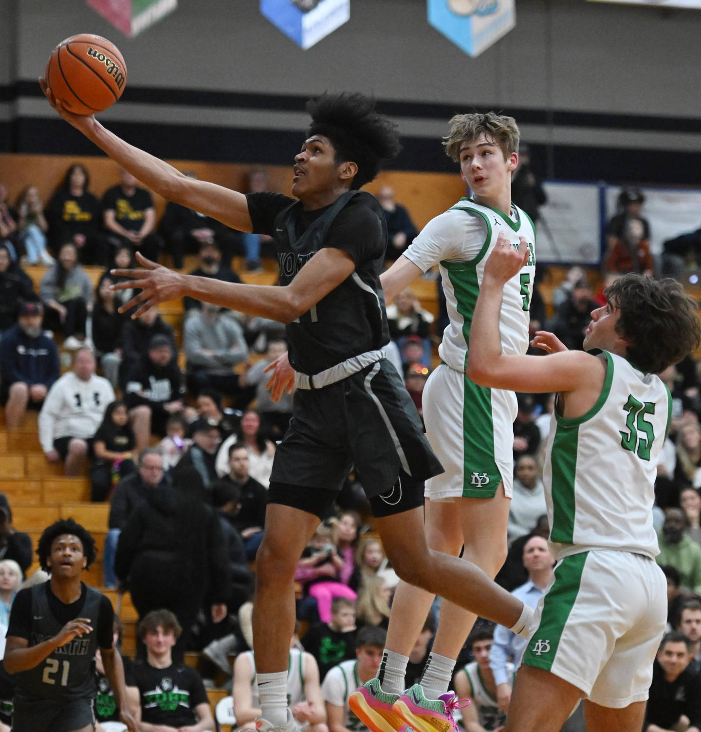 Glenbard North’s JJ Hernandez, left, drives to the basket against York defenders Kyle Waltz, middle, and Braden Richardson during the final of the Addison Trail Sectional on Friday, March 1, 2024 in Addison.