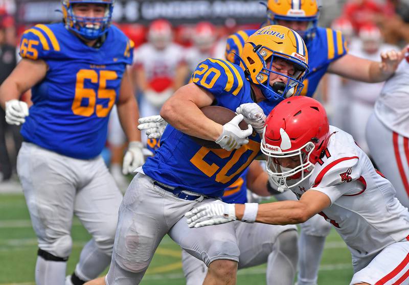 Lyons Township’s E.J. Kuhlman (20) tries to power past Hinsdale Central’s Charles Novatney during a game on September 20, 2025 at Lyons Township High School in LaGrange.