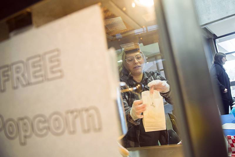 Chrissy Palacz of Americorps dishes up popcorn Wednesday, April 20, 2022 at Sauk Valley Community College's Sauk Fest. Many school clubs and local organizations took advantage of the fun free day at the school to meet with students and and showcase their programs.