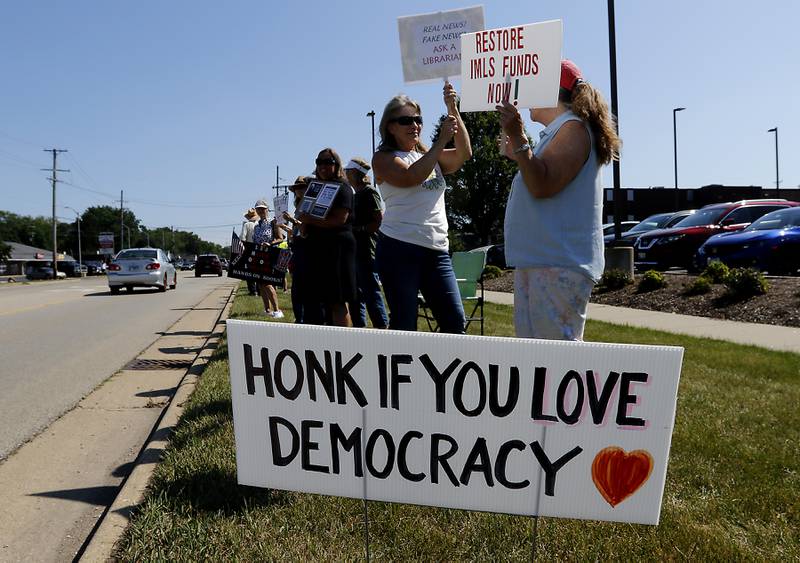 Protesters line Route 31 in front of the McHenry Public Library on Friday, June 20, 2025, during a Save Our Libraries Protest hosted by Indivisible McHenry County to draw attention to cuts to the nation’s libraries by the Trump administration.