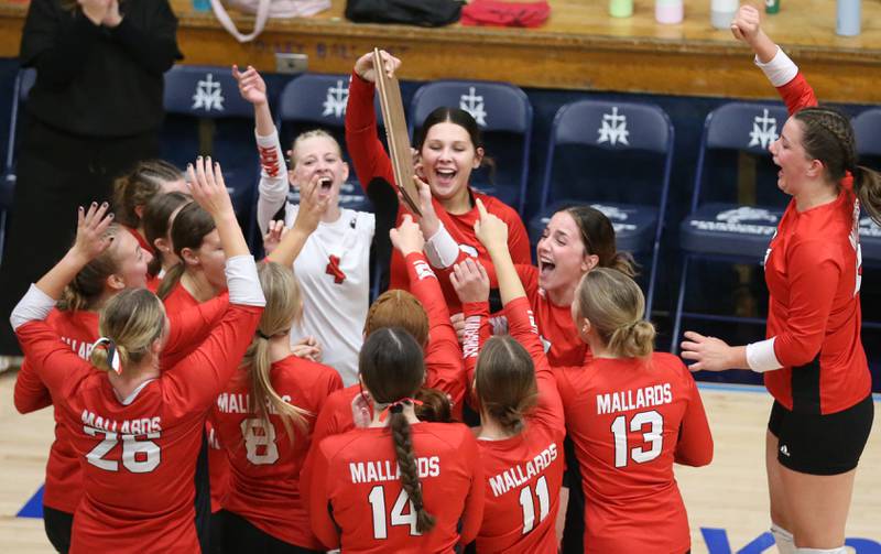 Members of the Henry-Senachwine volleyball team celebrate while hoisting the Tri-County Championship plaque after defeating Seneca on Thursday, Oct. 17, 2024 in Bader Gym at Marquette High School.