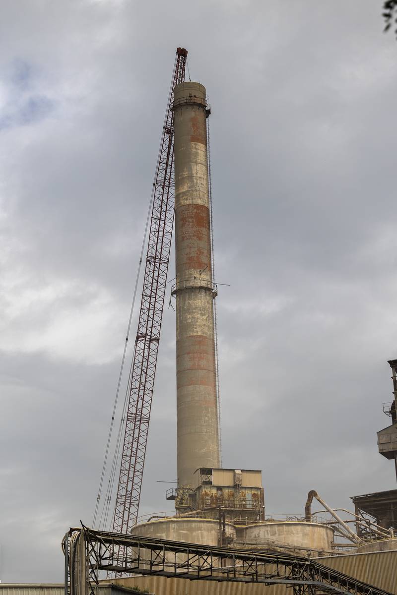 A crane operator works to demolish the 310-foot smokestack at the St. Mary’s Cement plant Monday, July 21, 2025, in Dixon.