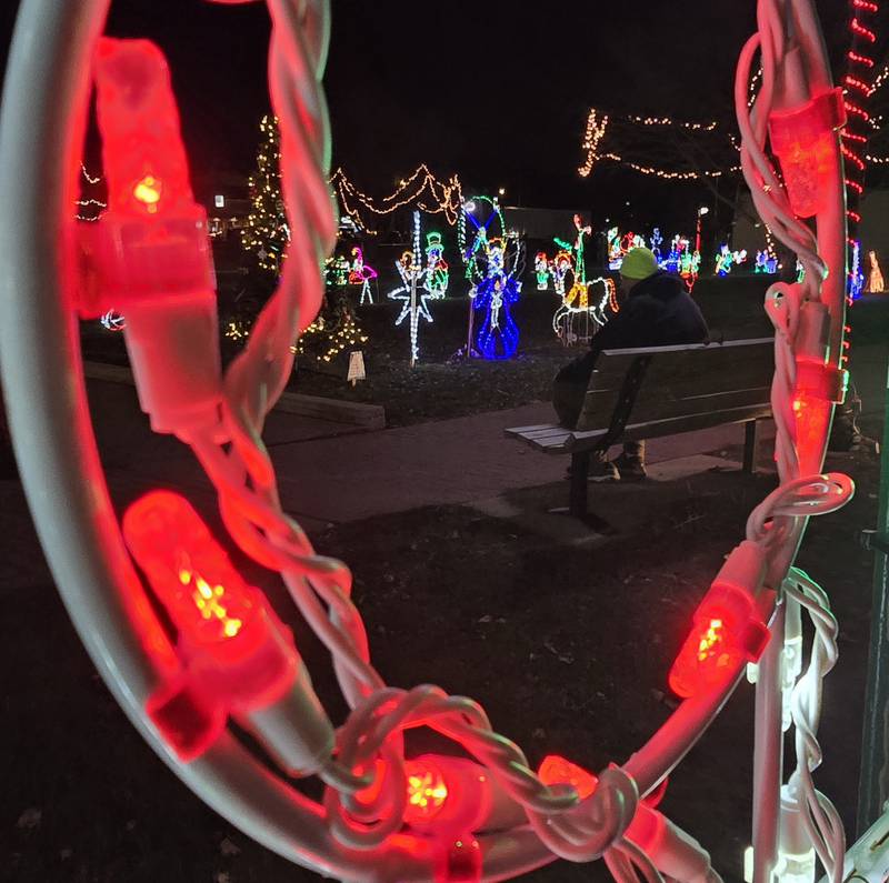 A man takes in the Christmas light displays Saturday, Dec. 7, 2024, while sitting on a bench at Knudson Park in Marseilles.