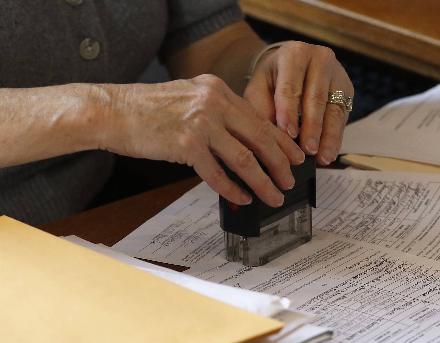 Jane Howie, an executive assistant and election official with the city of Woodstock, stamps the candidate filing papers of Wendy Barker, who is running for the City Council, on Monday, Nov. 28, 2022, at City Hall. Monday was the last day to file for the cities of Woodstock and Crystal Lake.