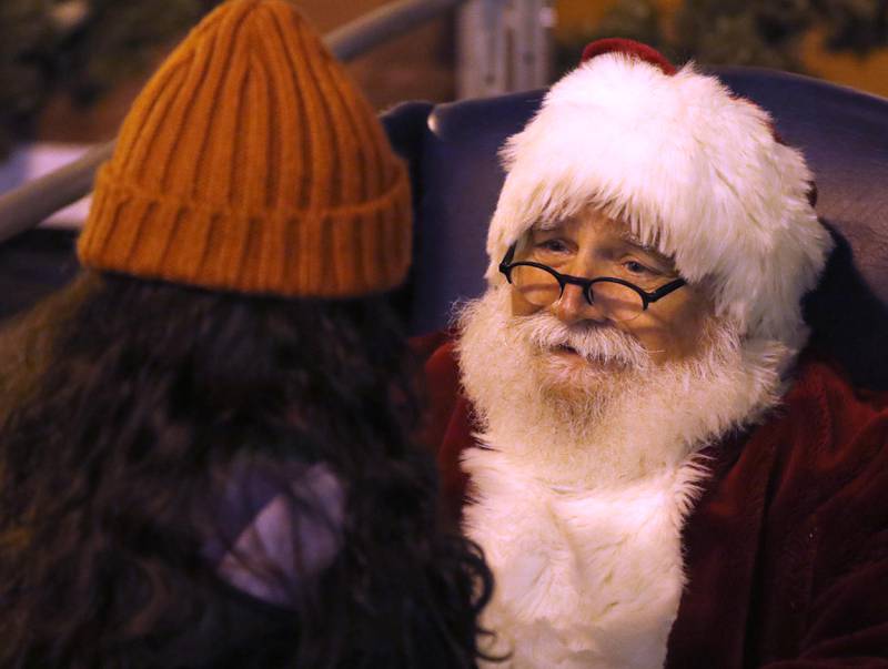 Santa Claus talks with a young girls during the Lighting of the Square on Friday, Nov. 28, 2025, in Woodstock.The annual holiday season event featured brass music, caroling, free doughnuts and cider, food trucks, festive selfie stations and shopping.