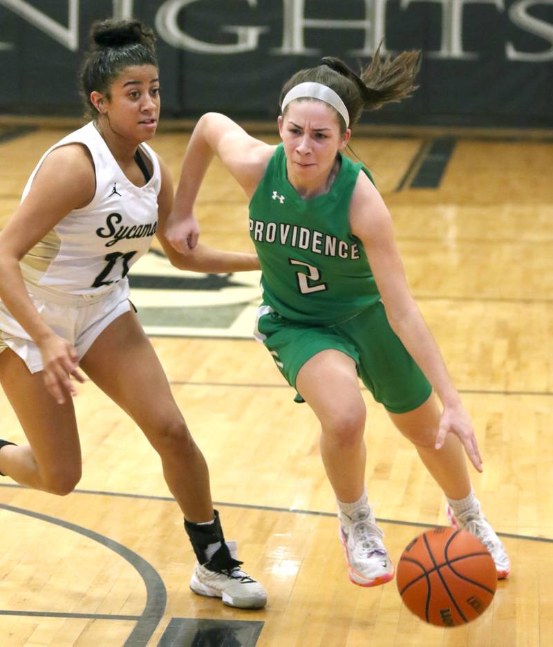 Providence Catholic's Kelly Knight drives by Sycamore's Jakiya Thompson during their game Tuesday, Feb. 22, 2022, in the Class 3A Kaneland sectional in Maple Park.