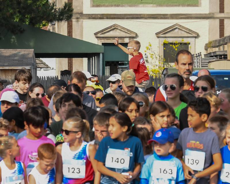 A young kids dash 1-mile fun run gets a boost to wave to his adoring fans before the start of the race on Saturday Sept. 8, 2024, held at Brookfield Zoo in Brookfield.
