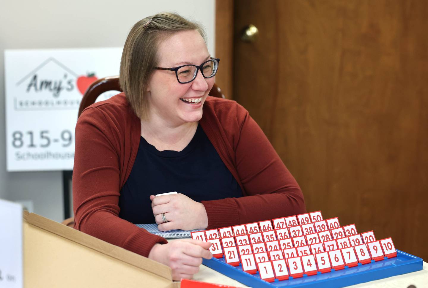 Amy Peura, owner of Amy’s School House, a kindergarten through twelfth-grade tutoring business, plays What’s My Number, a game that teaches math skills Friday Jan. 5, 2024, at her office in DeKalb. Peura recently moved from Sycamore to a new location on North First Street in DeKalb.