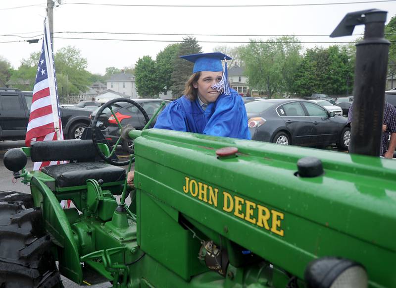 Jacob Piquette starts a 1947 John Deere track that he drove to his graduation ceremony Sunday, May 15, 2022, at Woodstock High School.