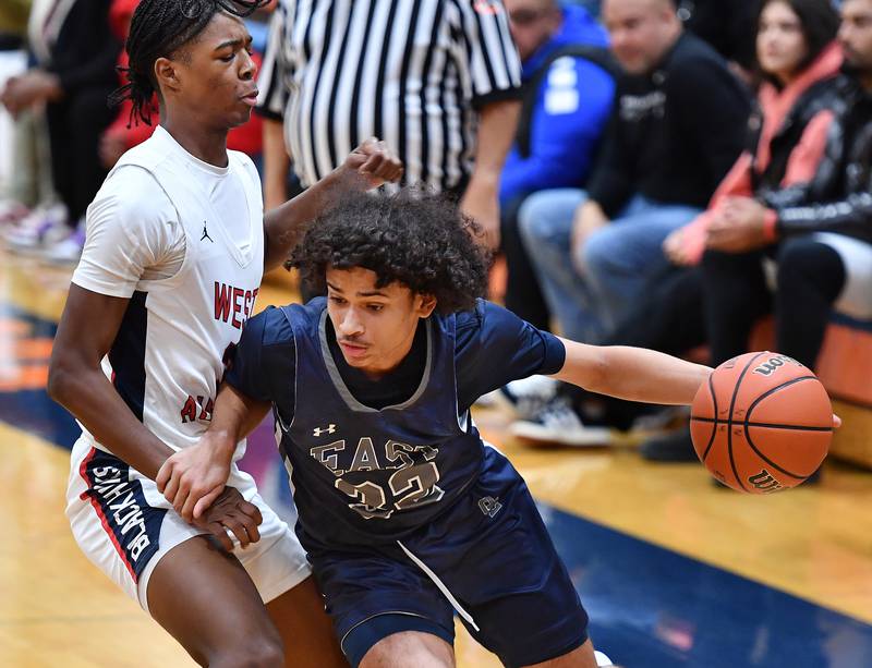 Oswego East's Jehvion Starwood drives past West Aurora’s Jayvyn Marion during a Hoops for Healing tournament game on Nov. 20, 2023 at Naperville North High School in Naperville.