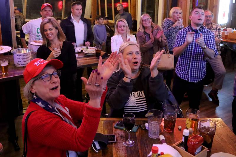 Republicans and supporters, including Rita Heuel, left, and Theresa Fronczak, both of Crystal Lake, applaud as Lindsey Graham is projected as winner during an election night watch party for local republicans at Niko's Red Mill Tavern on Tuesday, Nov. 3, 2020 in Woodstock.