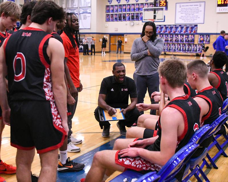 Glenbard East's head coach Eric Kelly talks with the team during a break in the action on Tuesday Feb. 3, 2026, while traveling to take on Riverside-Brookfield High School.