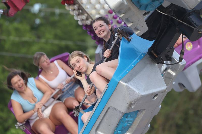 A girls takes a call while riding the Obiter with a friend at Old Canal Days on Friday June 7, 2024 in Lockport.