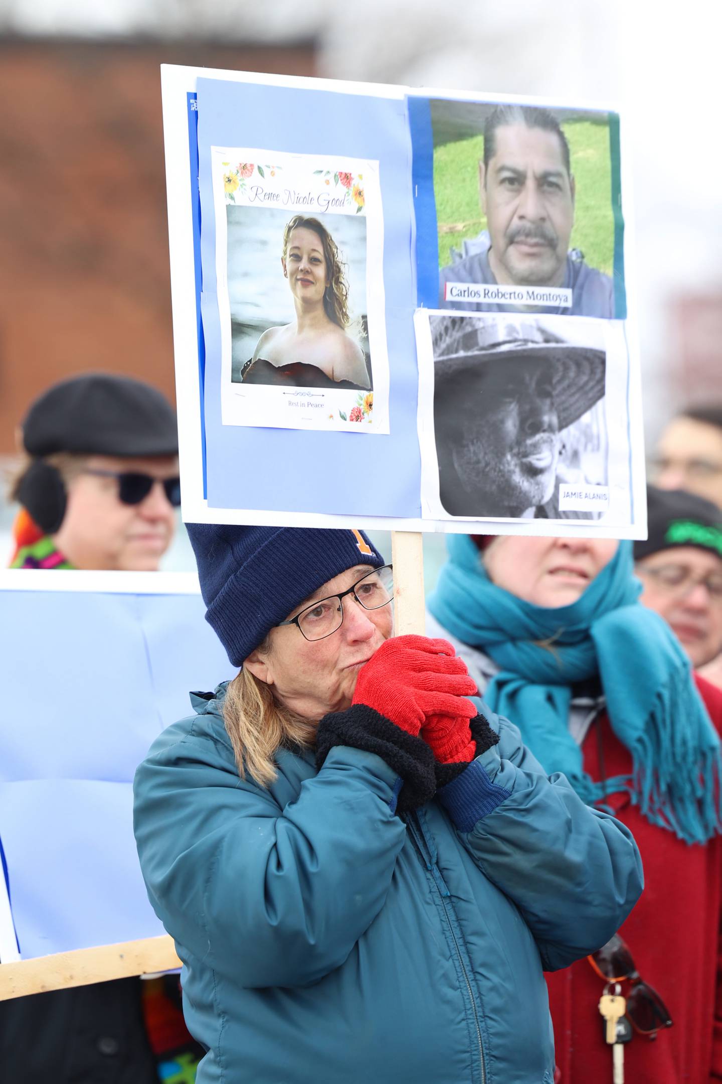 Amy Litherland, of Bourbonnais, listens to an emotional speech while holding a sign reflecting three deaths linked to ICE events, including Renee Nicole Good, Carlos Roberto Montoya and Jamie Alanis, during an ICE Out for Good protest and vigil at The Grow Center in Bourbonnais on Sunday, Jan. 11, 2026.