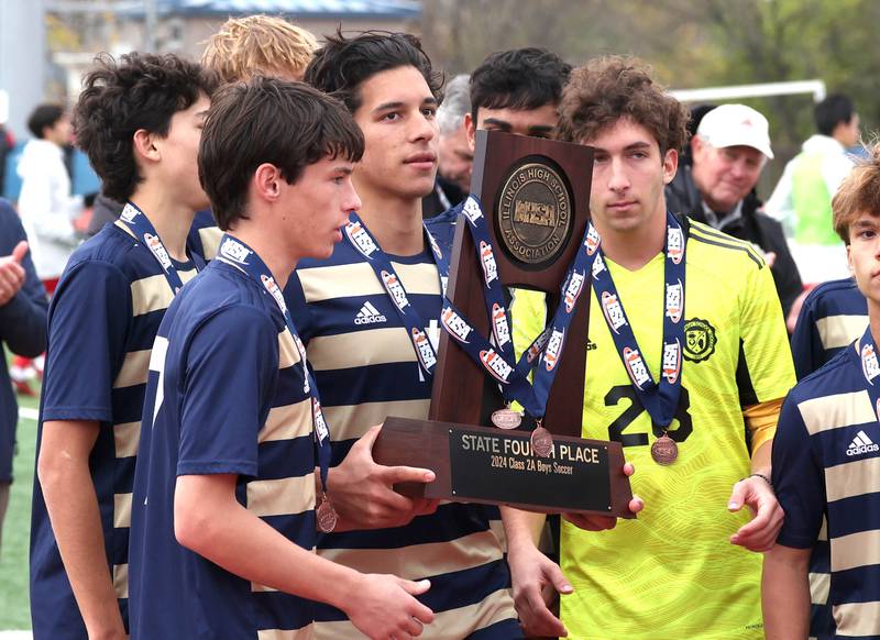 Lemont players accept the 4th place trophy Saturday, Nov. 9, 2024, after losing to Prairie Ridge in the Class 2A state third place game at Hoffman Estates High School.