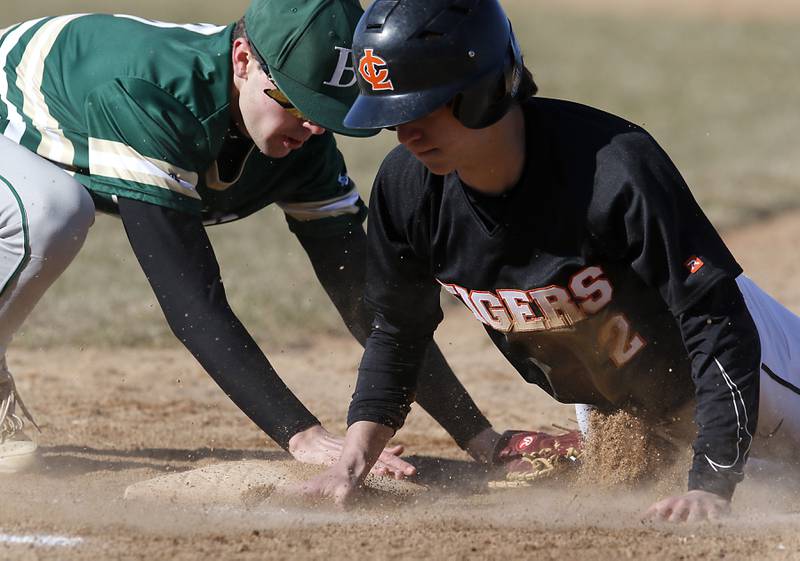 Crystal Lake Central's Ben Freese dives back to first base safely as Boylan’s John Kerestes tries to tag Freese during a nonconference baseball game Wednesday, March 29, 2023, at Crystal Lake Central High School.