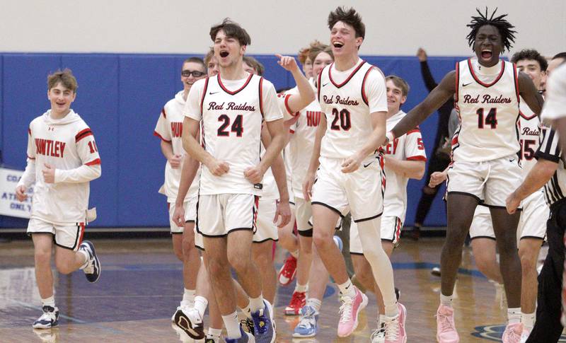 Huntley’s Red Raiders celebrate a win over Crystal Lake South in varsity basketball tournament title game action at Johnsburg Friday.