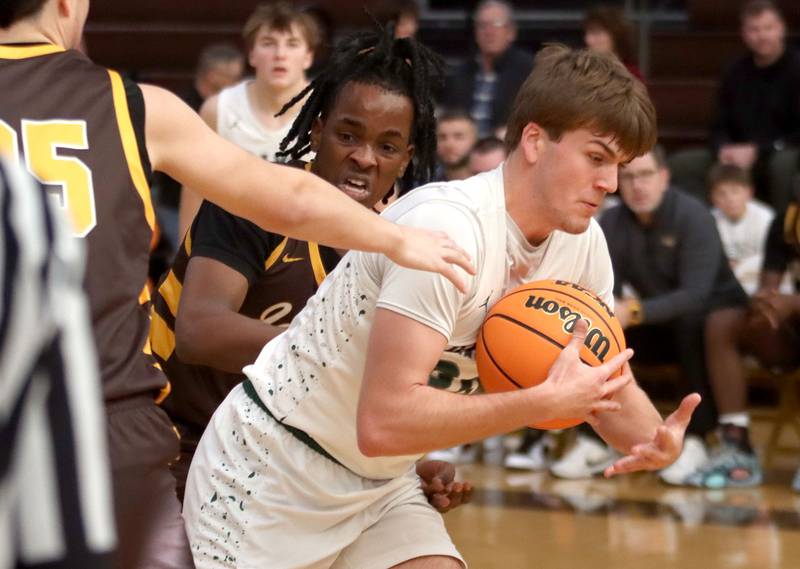 Jacobs’ Malachi Bell, back, tussles with Grayslake Central’s Cole Halverson in varsity boys basketball Hinkle Holiday Classic action on Tuesday, Dec. 23, 2025, at Jacobs High School in Algonquin.